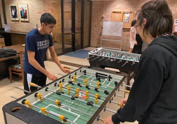 Lovetteers playing foosball in Lower Commons