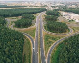 a highway intersection with a road and trees