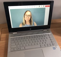 A laptop showing Emily dialled into a vide call