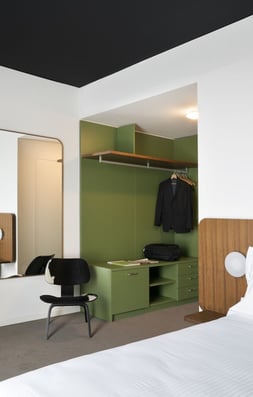a bedroom with a bed, desk, and chair