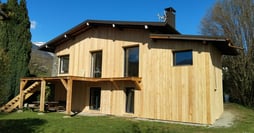 a house with a wooden siding and a staircase leading to a deck