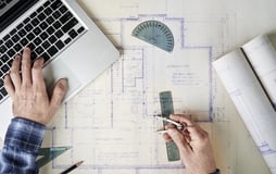 Un arquitecto revisando planos o usando un software de diseño 3D