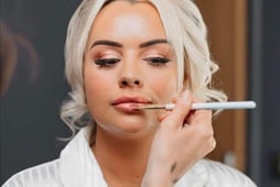 a blonde women having her bridal makeup done