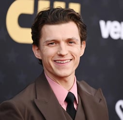 Tom Holland attending The Crowded Room premiere in a tailored tux