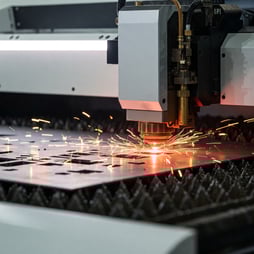 a machine cutting metal with sparks and sparks