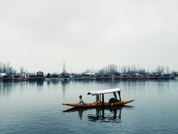 a shikara in the lake with a person on it