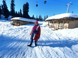 a woman in a red coat and a pink scarf near gondola ride