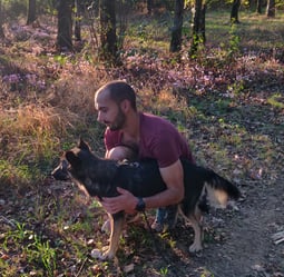 l'éducateur canin avec son chien type berger dans la foret