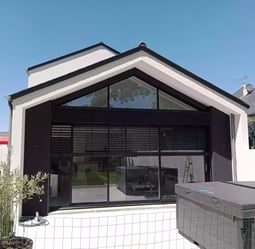 Maison moderne avec portes et fenêtres en aluminium, mettant en valeur la menuiserie extérieure