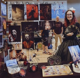 a woman in a black dress standing in front of a display of art