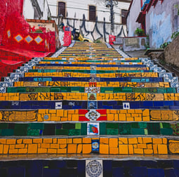 a staircase case with colorful painted steps leading up to a stairway, Selaròn, Rio de Janeiro