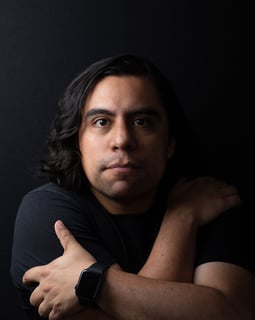 A man with long hair and a watch on his wrist