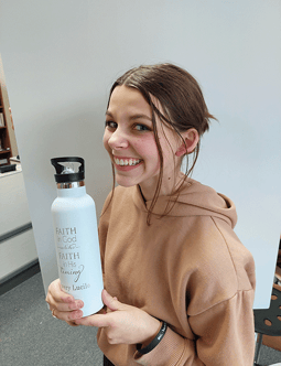 a woman holding a bottle of water in her hand