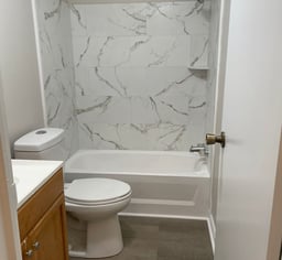 a bathroom with a toilet and a tub in it