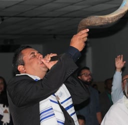 a man blowing a horn horn while a woman in a white dress