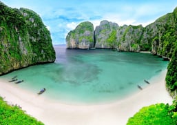 a beach with boats and corals in the water