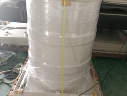 a large stack of white plastic bags on a pallet