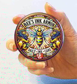 Hand holding tin of all natural tattoo aftercare product Bee's Ink Armor Daily Ink Care