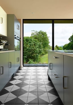 Black and white floor tiles laid in a diamond pattern with oak wood flooring