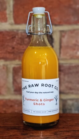 Cold Pressed Turmeric & Ginger health and Wellness Shots in a glass swing top bottle from The Raw Root Co.