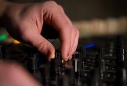 gros plan sur la main du DJ qui actionne un bouton sur sa platine
