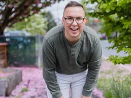 A happy autistic male adult, smiling at the camera