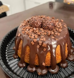 Delicioso bolo de chocolate com cobertura de ganache, decorado com granulado e bombons, perfeito par