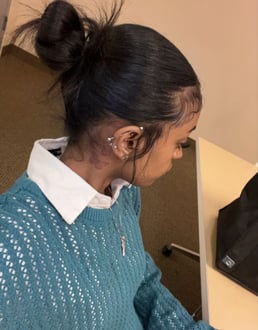 a young girl sitting at a desk with a laptop. slick hair
