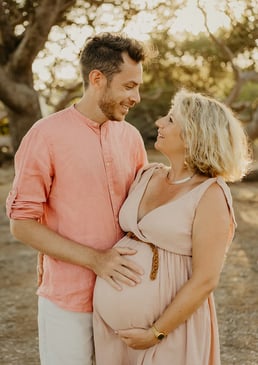 Couple qui se regarde tendrement au coucher du soleil – séance photo grossesse en extérieur Gard