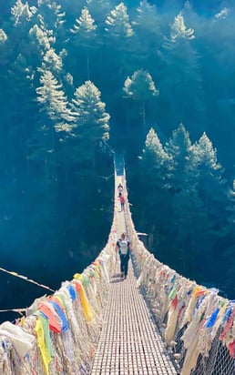 Suspension bridge along the Everest Valley trek, surrounded by Himalayan peaks.