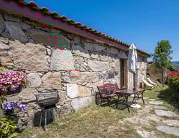 a stone wall with a bench and chairs