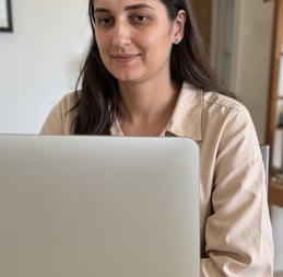 a woman sitting at a table with a laptop