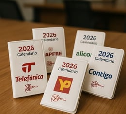 Calendarios de bolsillo personalizados 2026 con logos de empresas en Lima, Perú, diseño práctico y colorido sobre mesa de ofi