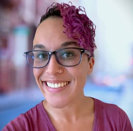 a woman with glasses and a purple shirt