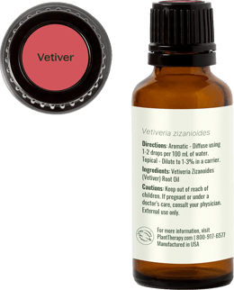 Vetiver essential oil bottle showing usage directions, cautions and red-labeled cap top view