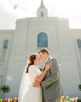 a bride and groom standing in front of a church