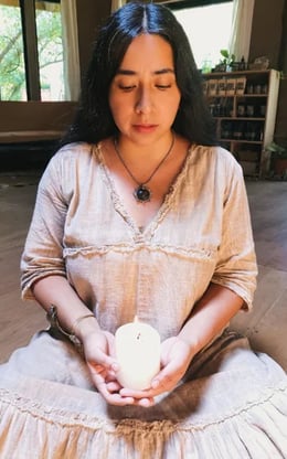 Mujer sentada sosteniendo una vela encendida