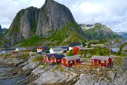 a mountain range with a red house and a mountain in the background