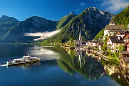 a boat is coming down the river in a beautiful mountain setting