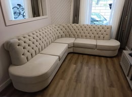 Sofá de canto feito sob medida com design redondo e encosto em capitonê