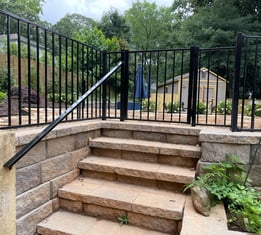 a black and white staircase with a black railing and a black railing