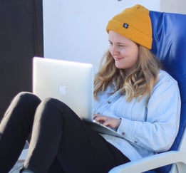 a woman sitting in a chair with a laptop on her lap