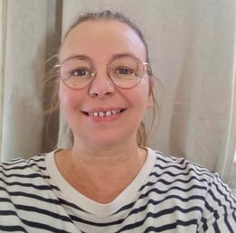 Femme blonde avec des lunettes et un pull rayer noir et blanc