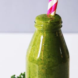 a bottle of green smoothie with a strawberries and a strawberries