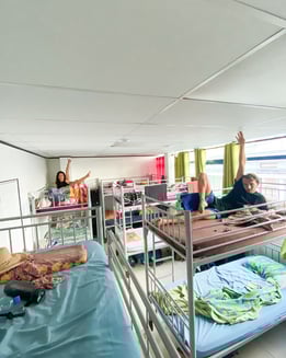 Dormitory room in a hostel in Tahiti with multiple beds and basic furnishings.
