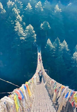 Passage d'un pont suspendu avec drapeaux.