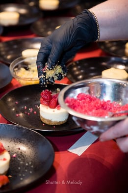 Der Chefkoch dekoriert einen Käsekuchen mit Fruchtkaviar.