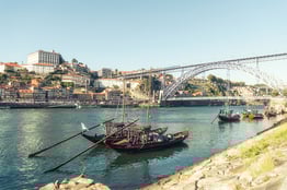 multiple boats (rabelos) and a typical view of Porto city and Douro river