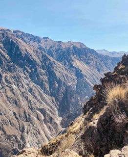 View of the Colca Canyon near Arequipa, Peru, with steep cliffs and a clear sky.
