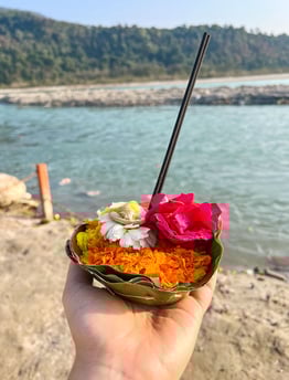 Close-up of flowers and incense sticks arranged as an offering during a ritual by the Ganges River.
